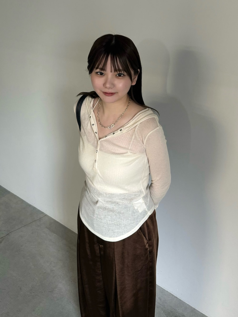 ホワイト系のTシャツ/カットソー、ホワイト系のキャミソール、ブラウン系のスラックスを着用したレディースの夏コーディネートの3枚目の写真