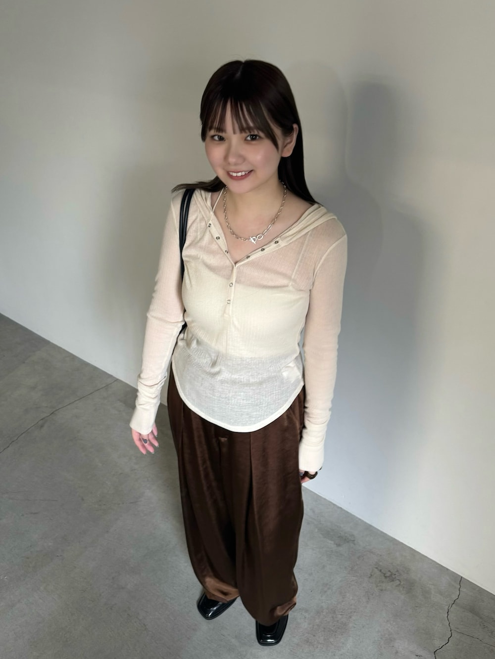 ホワイト系のTシャツ/カットソー、ホワイト系のキャミソール、ブラウン系のスラックスを着用したレディースの夏コーディネートの5枚目の写真