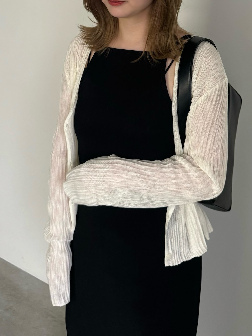 ブラック系のワンピース、ホワイト系のカーディガン/ボレロ、ブラック系のショルダーバッグを着用したレディースの夏コーディネートの6枚目の写真