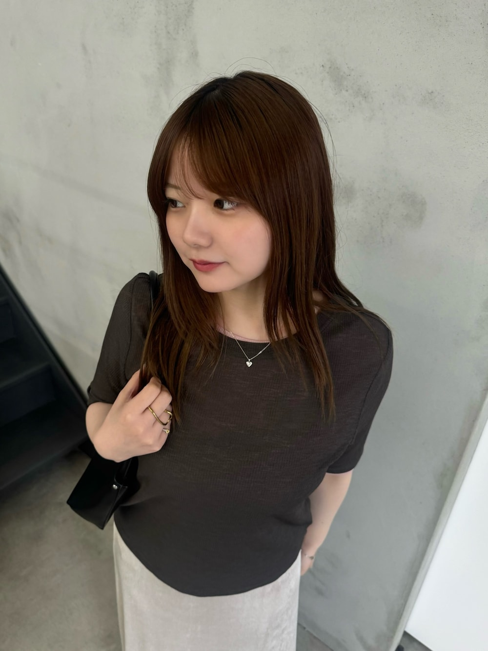 グレー系のTシャツ/カットソー、ホワイト系のスカート、ブラック系のスリッポンを着用したレディースの夏コーディネートの4枚目の写真