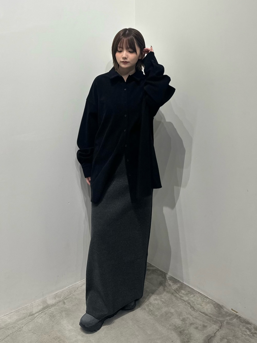 ブラック系のシャツ/ブラウス、グレー系のスカート、グレー系のスニーカーを着用したレディースの秋コーディネートの2枚目の写真