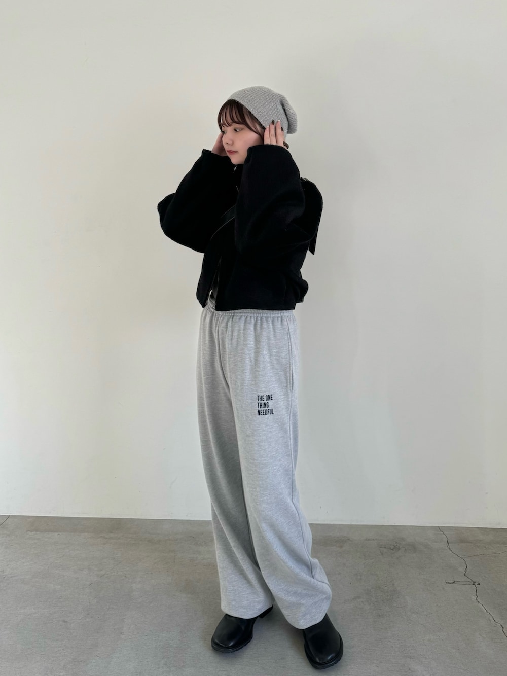 グレー系のスウェットパンツ、ブラック系のショルダーバッグ、ブラック系のステンカラーコートを着用したレディースの秋コーディネートの4枚目の写真