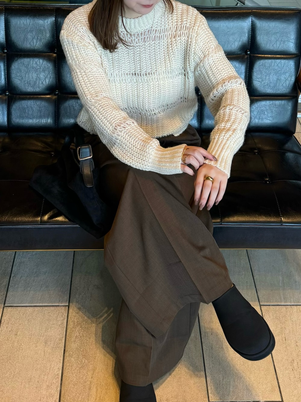 ホワイト系のニット/セーター、ホワイト系のキャミソール、ブラウン系のスラックスを着用したレディースの秋コーディネートの3枚目の写真