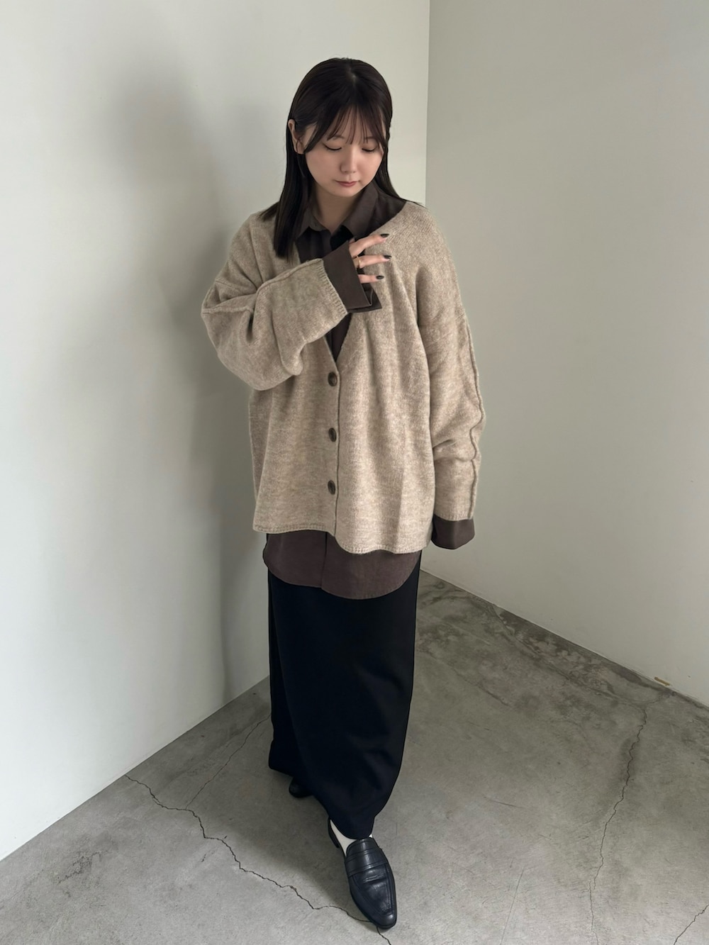 ベージュ系のカーディガン/ボレロ、ブラウン系のシャツ/ブラウス、ブラック系のスカートを着用したレディースの秋コーディネートの2枚目の写真