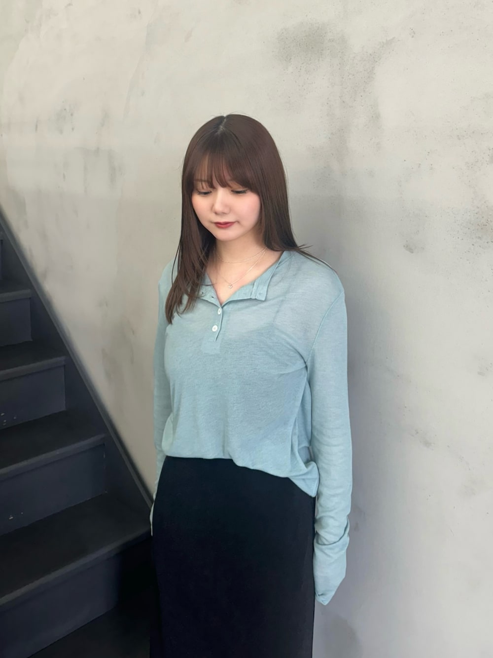 ブルー系のTシャツ/カットソー、ブラック系のキャミソール、ブラック系のスカートを着用したレディースの冬コーディネートの4枚目の写真