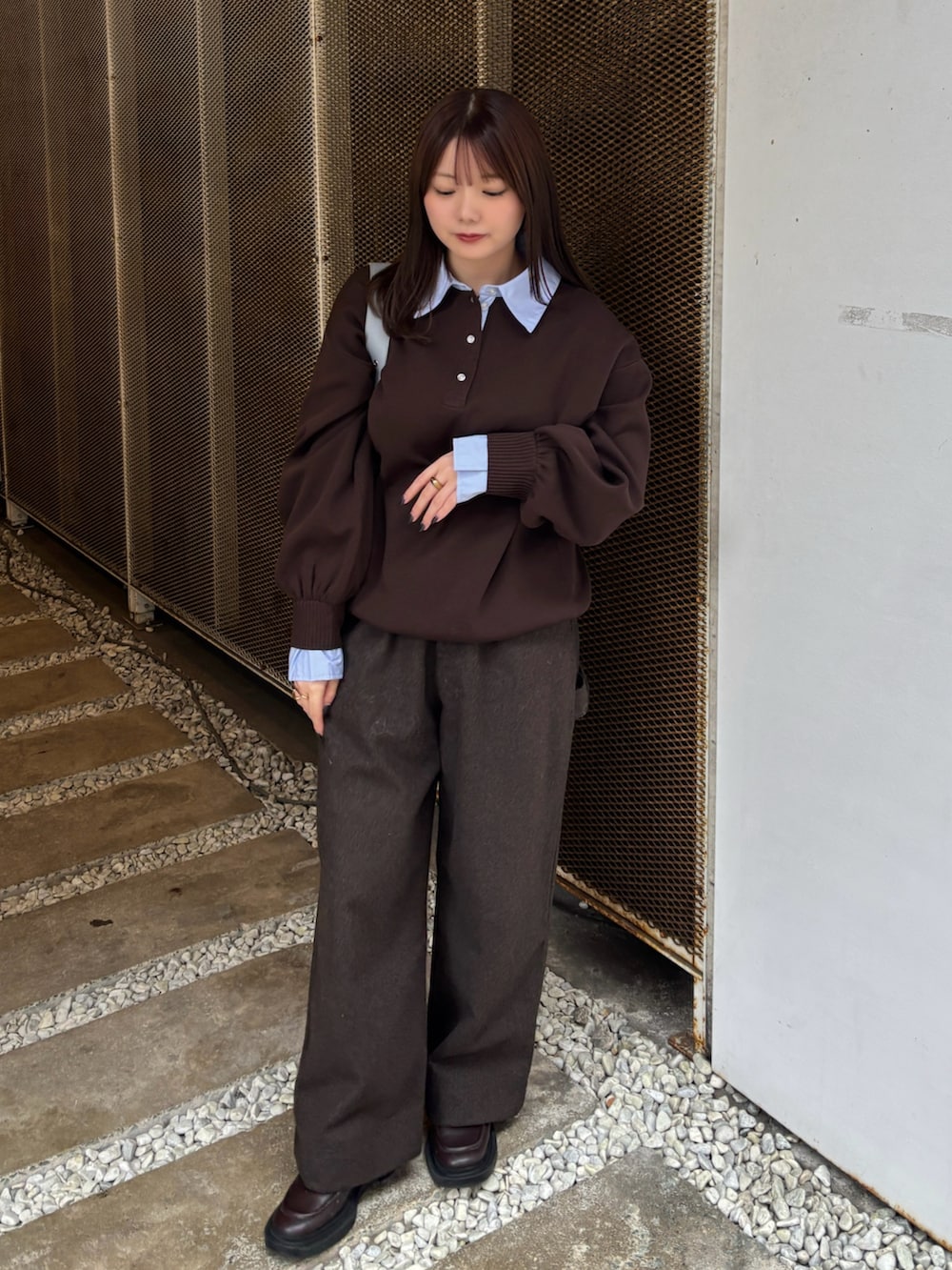 ブラウン系のニット/セーター、ブラウン系のその他パンツ、ブルー系のショルダーバッグを着用したレディースの秋コーディネートの2枚目の写真