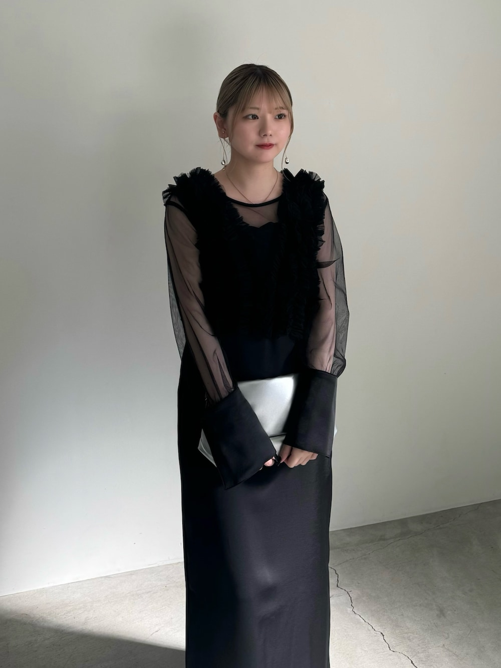 ブラック系のチューブトップ、ブラック系のドレス、シルバー系のショルダーバッグを着用したレディースの春コーディネートの4枚目の写真