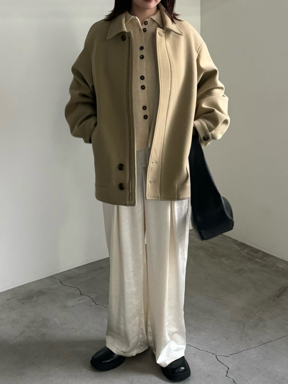 ベージュ系のカーディガン/ボレロ、ブラック系のショルダーバッグ、ベージュ系のその他アウターを着用したレディースの冬コーディネートの2枚目の写真