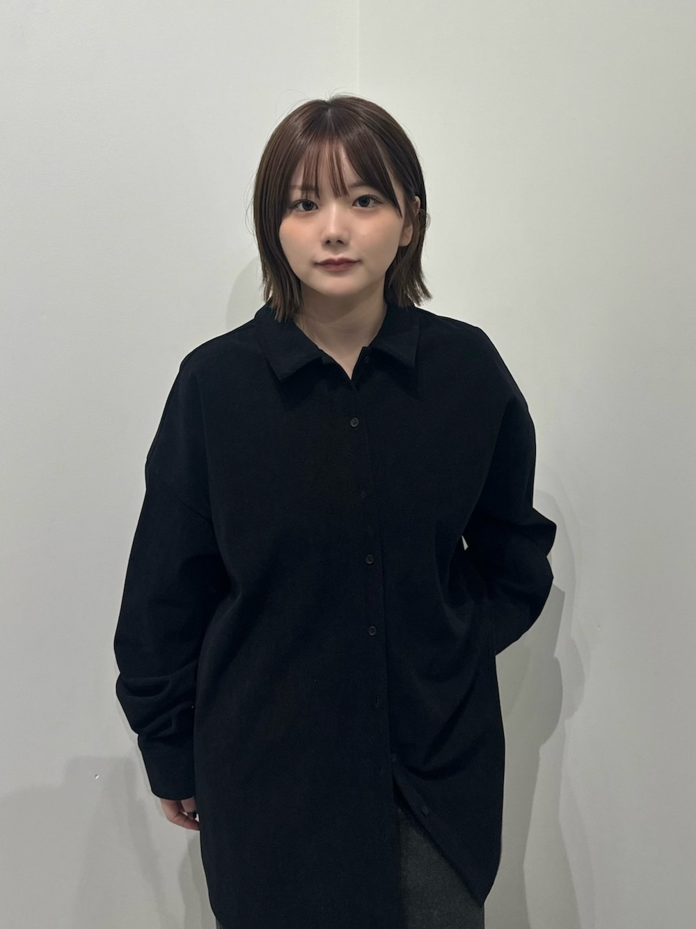 ブラック系のシャツ/ブラウス、グレー系のスカート、グレー系のスニーカーを着用したレディースの秋コーディネートの4枚目の写真
