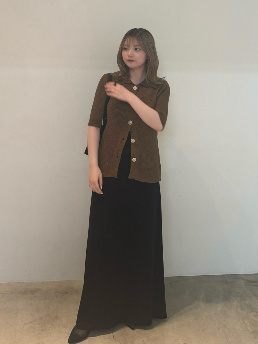 グリーン系のカーディガン/ボレロ、ホワイト系のキャミソール、ブラック系のスカートを着用したレディースの夏コーディネートの2枚目の写真