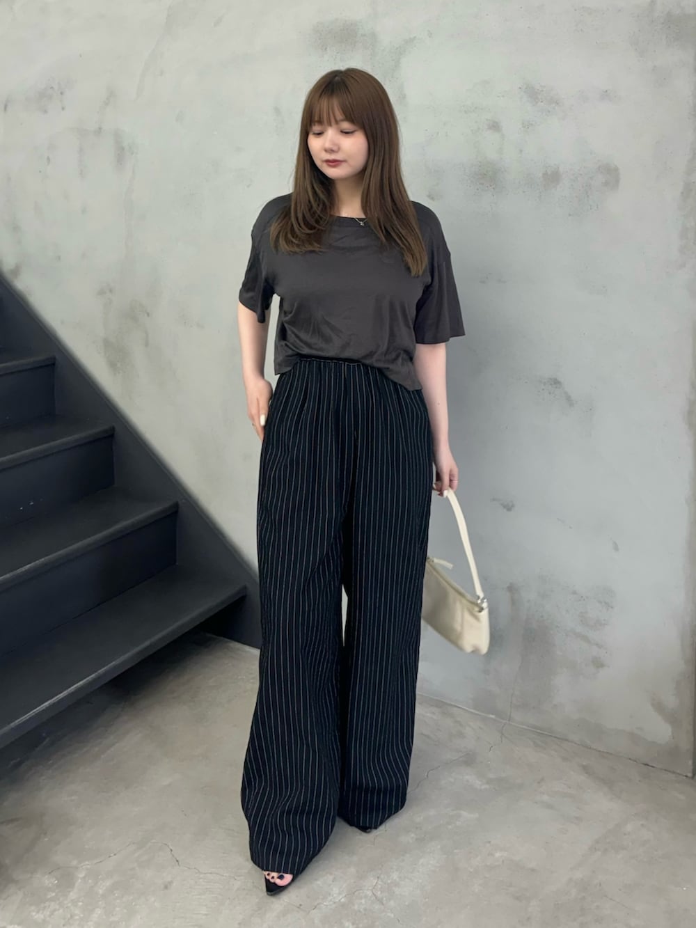 ブラック系のTシャツ/カットソー、ブラック系のその他パンツ、ホワイト系のハンドバッグを着用したレディースの夏コーディネートの2枚目の写真