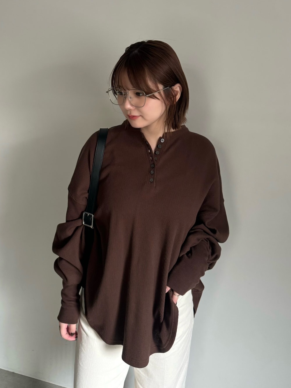 ブラウン系のTシャツ/カットソー、ベージュ系のその他パンツ、ブラック系のショルダーバッグを着用したレディースの秋コーディネートの4枚目の写真