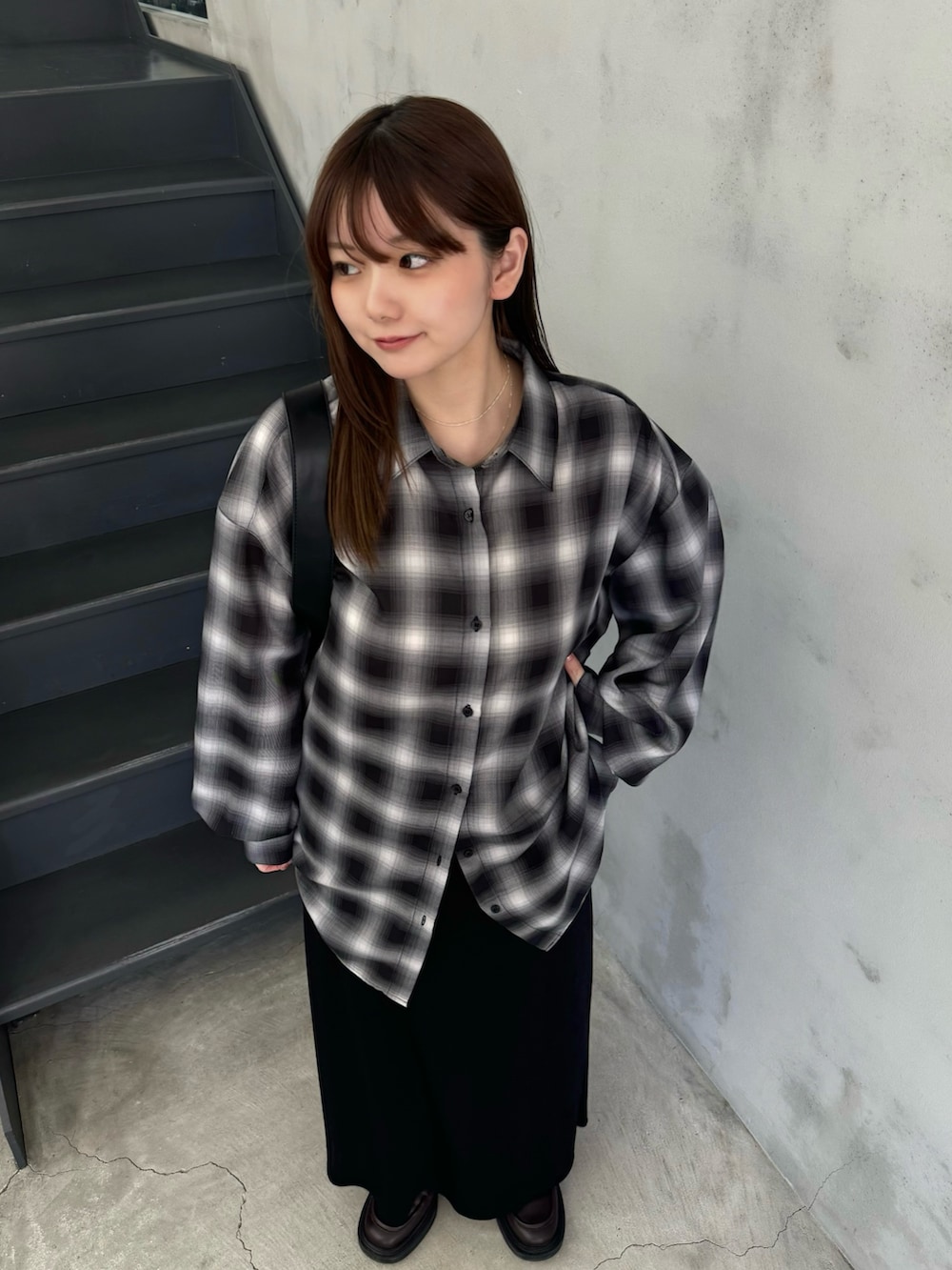 ブラック系のスカート、ブラック系のシャツ/ブラウス、ブラック系のショルダーバッグを着用したレディースの冬コーディネートの4枚目の写真