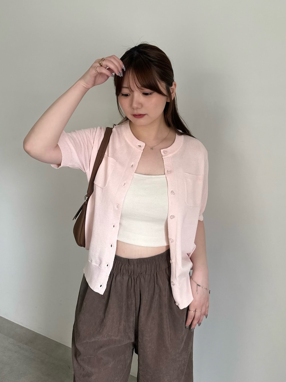 ピンク系のカーディガン/ボレロ、ホワイト系のキャミソール、ブラウン系のその他パンツを着用したレディースの夏コーディネートの6枚目の写真