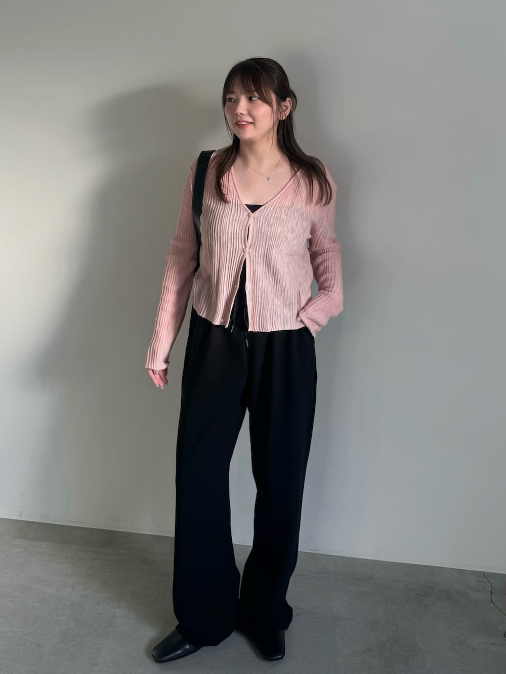 ブラック系のその他パンツ、ブラック系のスリッポン、ピンク系のカーディガン/ボレロを着用したレディースの春コーディネートの4枚目の写真