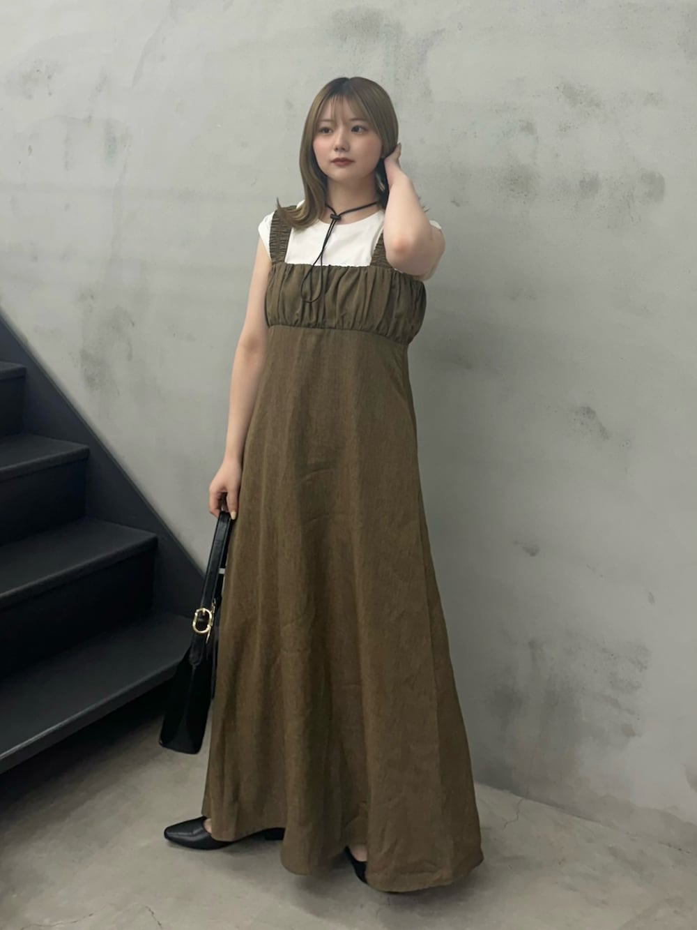 ブラウン系のワンピース、ブラック系のハンドバッグ、ホワイト系のTシャツ/カットソーを着用したレディースの夏コーディネートの4枚目の写真