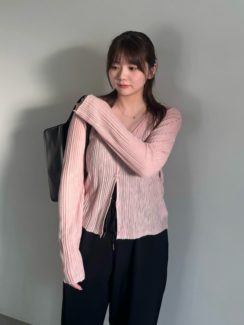 ブラック系のその他パンツ、ブラック系のスリッポン、ピンク系のカーディガン/ボレロを着用したレディースの春コーディネートの6枚目の写真