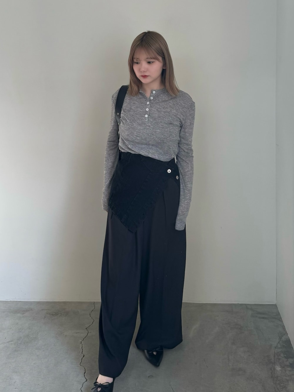 ブラック系のチューブトップ、ブラック系のスラックス、ブラック系のショルダーバッグを着用したレディースの春コーディネートの2枚目の写真