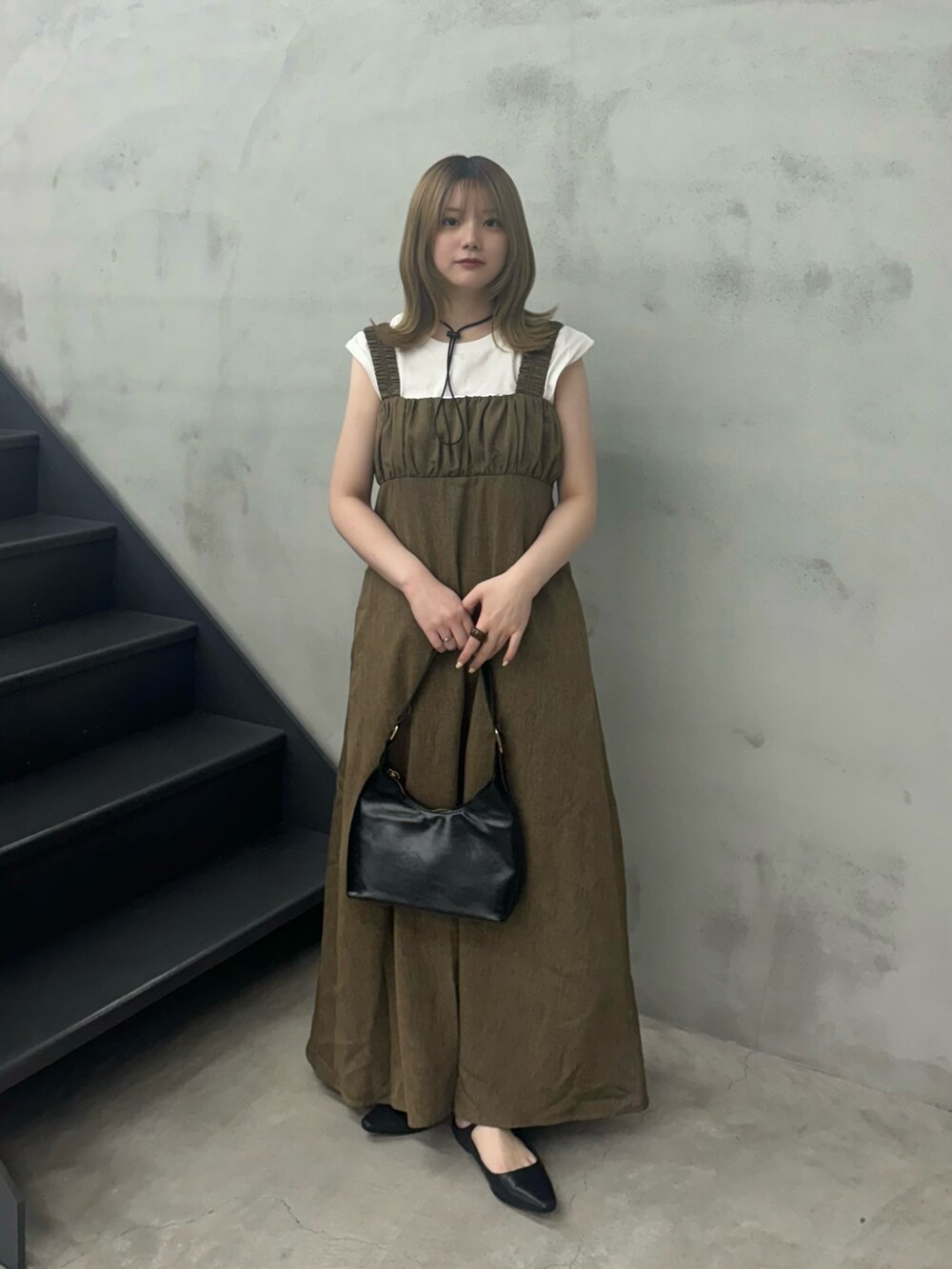 ブラウン系のワンピース、ブラック系のハンドバッグ、ホワイト系のTシャツ/カットソーを着用したレディースの夏コーディネートの2枚目の写真