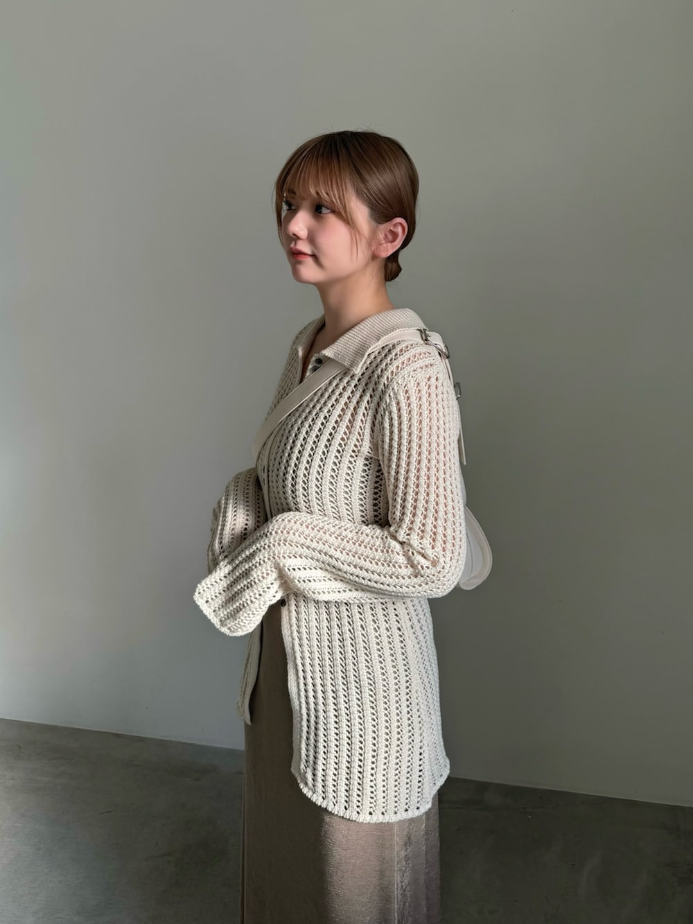 ベージュ系のスカート、ホワイト系のカーディガン/ボレロ、ホワイト系のショルダーバッグを着用したレディースの春コーディネートの4枚目の写真