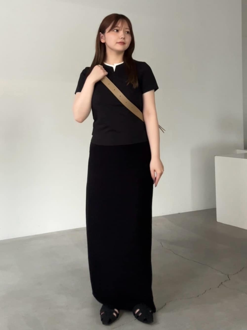 ブラック系のTシャツ/カットソー、ブラック系のスカート、ベージュ系のショルダーバッグを着用したレディースの夏コーディネートの2枚目の写真