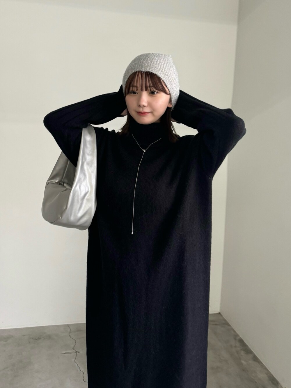 ブラック系のワンピース、シルバー系のショルダーバッグ、ブラック系のブーツを着用したレディースの秋コーディネートの3枚目の写真