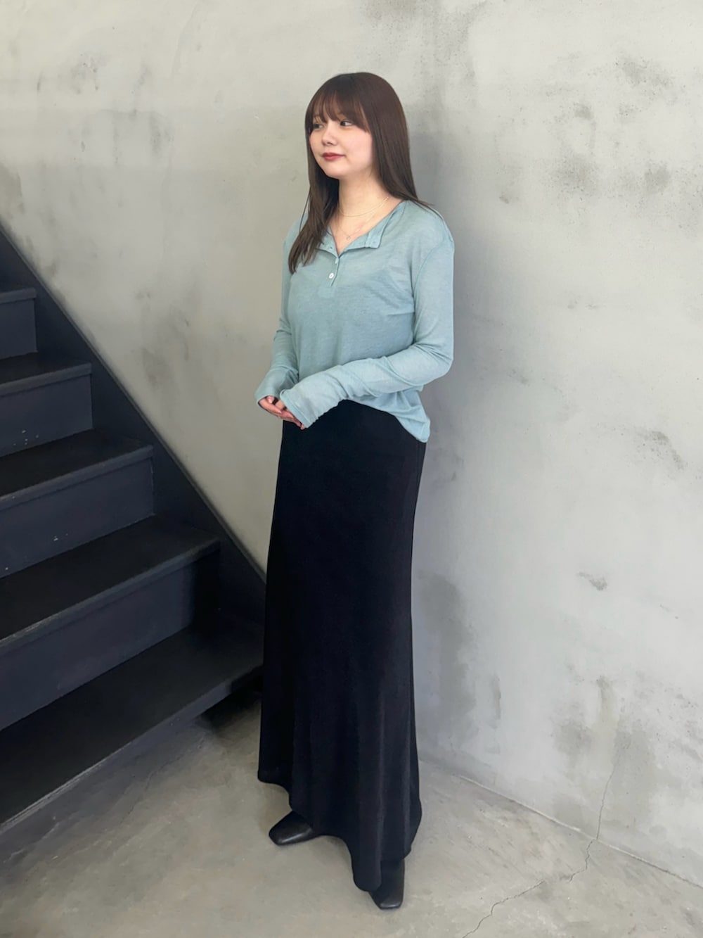 ブルー系のTシャツ/カットソー、ブラック系のキャミソール、ブラック系のスカートを着用したレディースの冬コーディネートの3枚目の写真