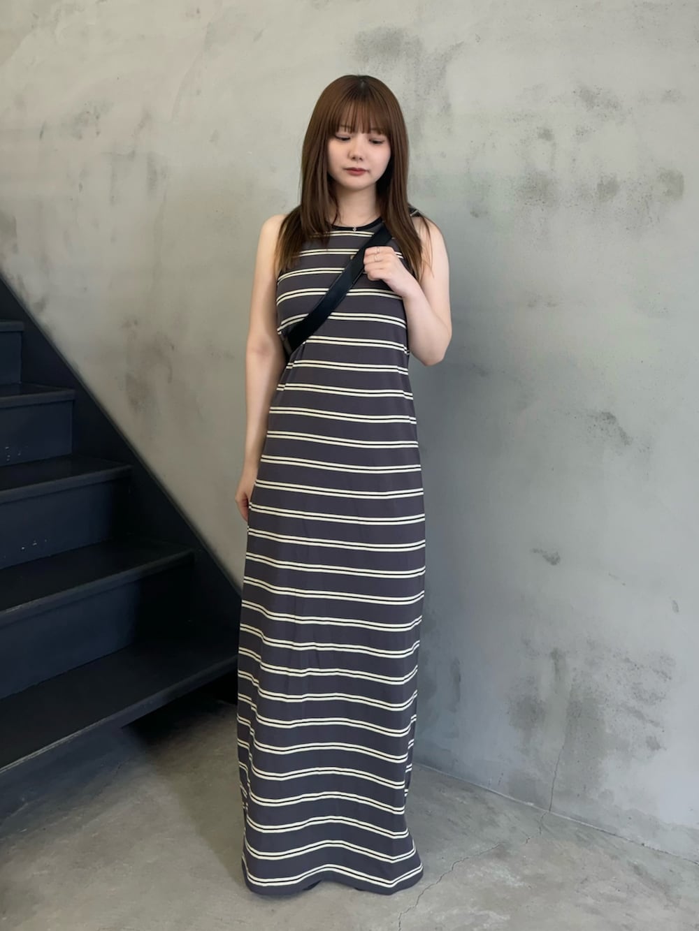 グレー系のワンピース、ブラック系のショルダーバッグ、ブラック系のサンダルを着用したレディースの夏コーディネートの2枚目の写真