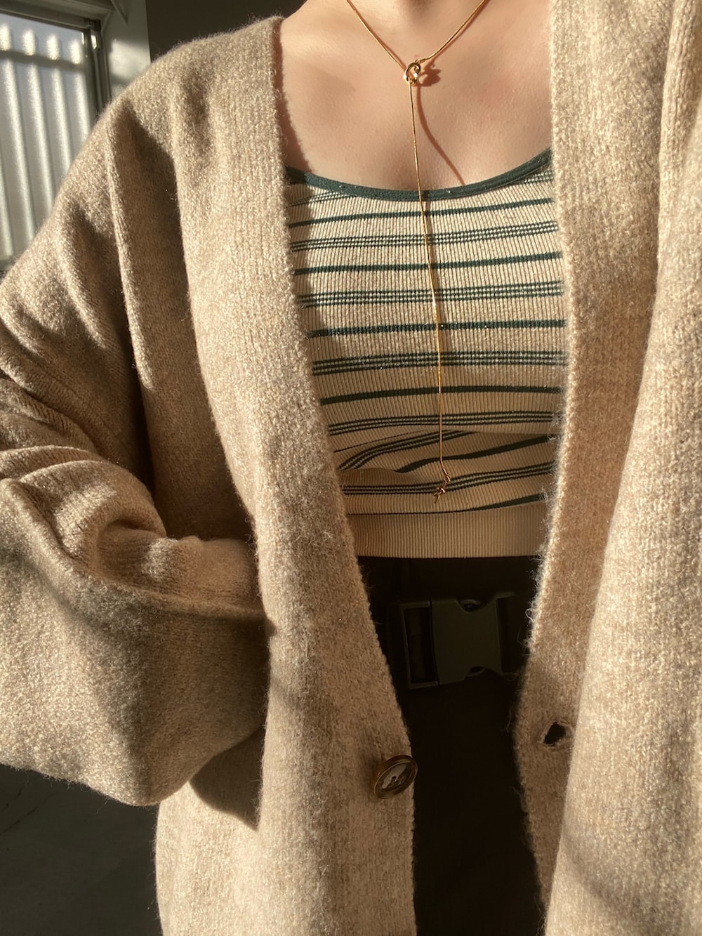 ベージュ系のカーディガン/ボレロ、ブラック系のスカートを着用したレディースの夏コーディネートの4枚目の写真