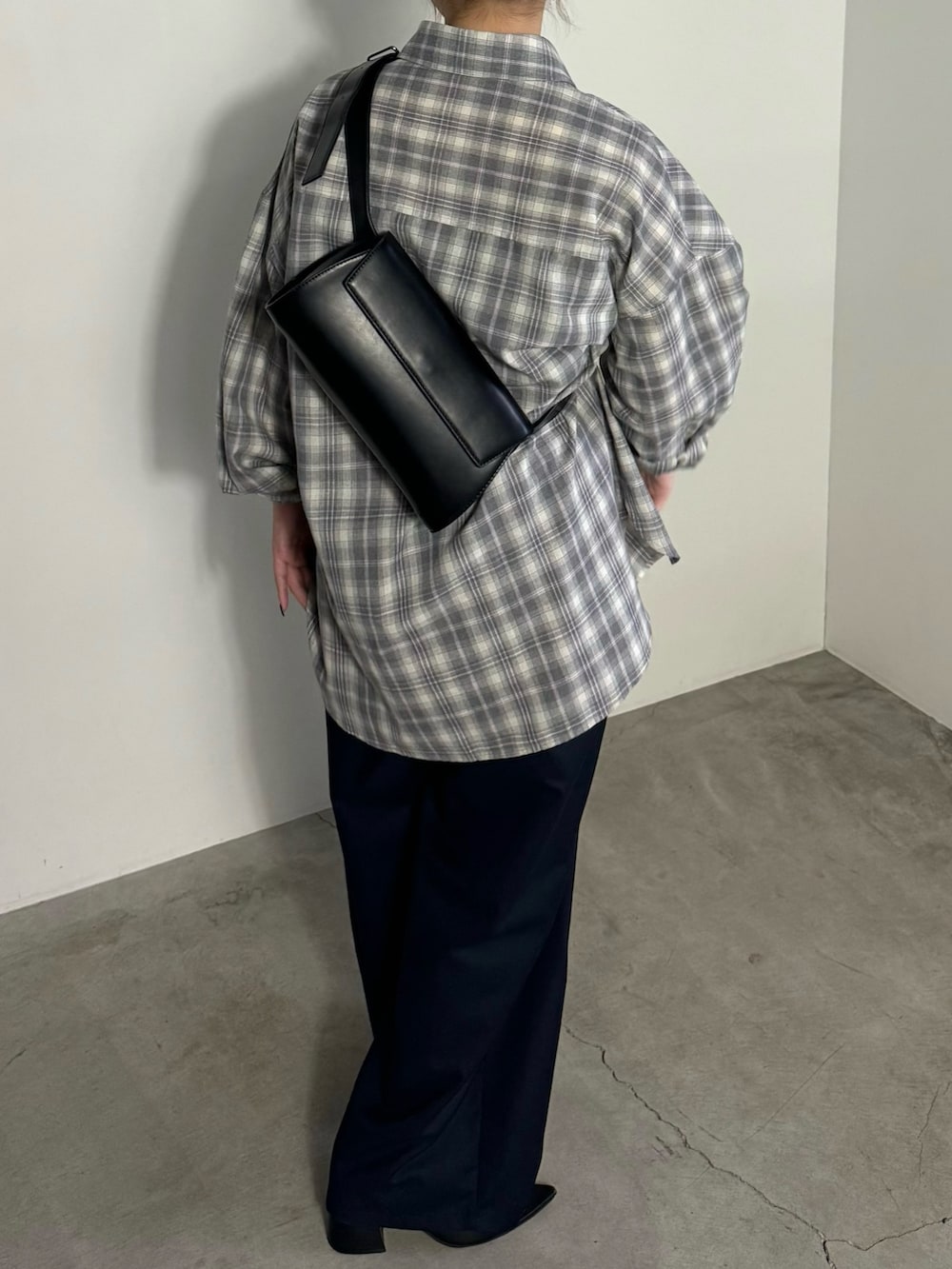 ブラック系のショルダーバッグ、グレー系のシャツ/ブラウス、ブルー系のスラックスを着用したレディースの冬コーディネートの4枚目の写真