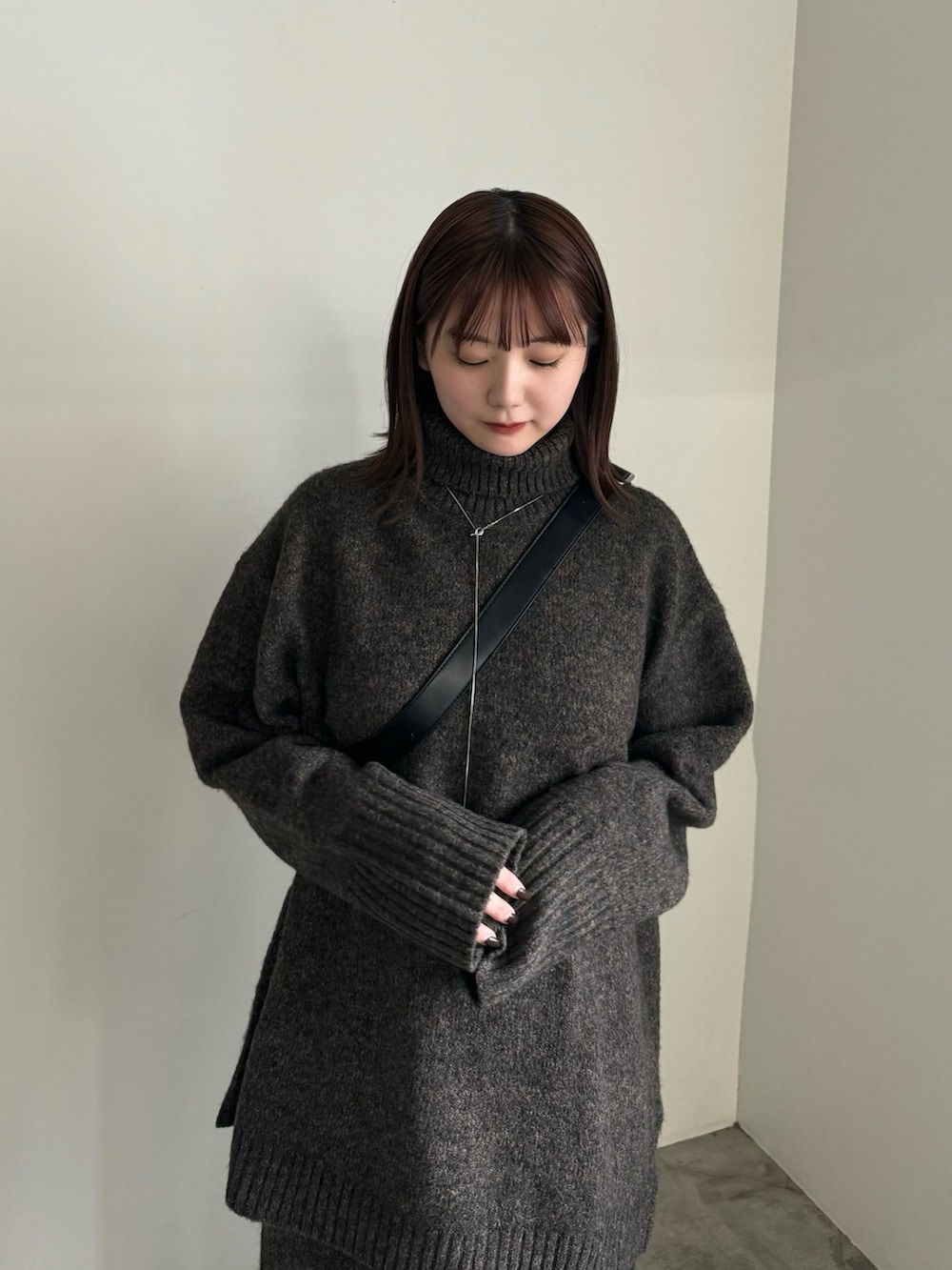 ブラウン系のニット/セーター、ブラウン系のその他パンツ、ブラック系のショルダーバッグを着用したレディースの秋コーディネートの3枚目の写真