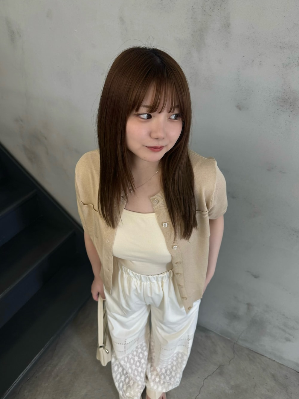 ベージュ系のキャミソール、ホワイト系のその他パンツ、ホワイト系のハンドバッグを着用したレディースの夏コーディネートの3枚目の写真