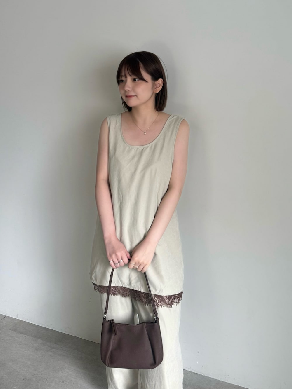 ベージュ系のその他パンツ、ブラウン系のスニーカー、ブラウン系のハンドバッグを着用したレディースの夏コーディネートの3枚目の写真