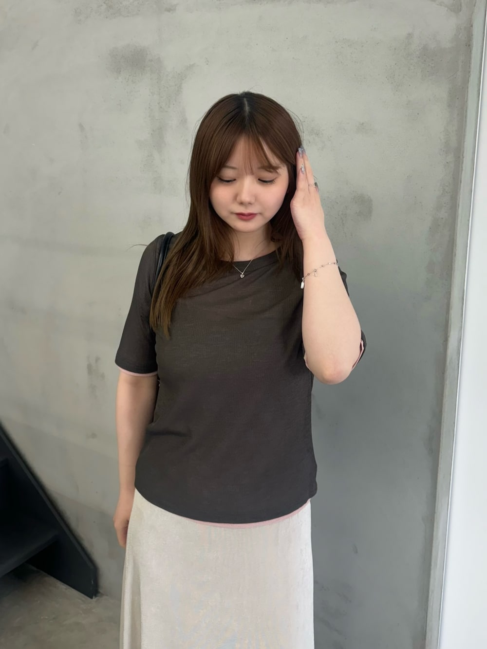 グレー系のTシャツ/カットソー、ホワイト系のスカート、ブラック系のスリッポンを着用したレディースの夏コーディネートの3枚目の写真