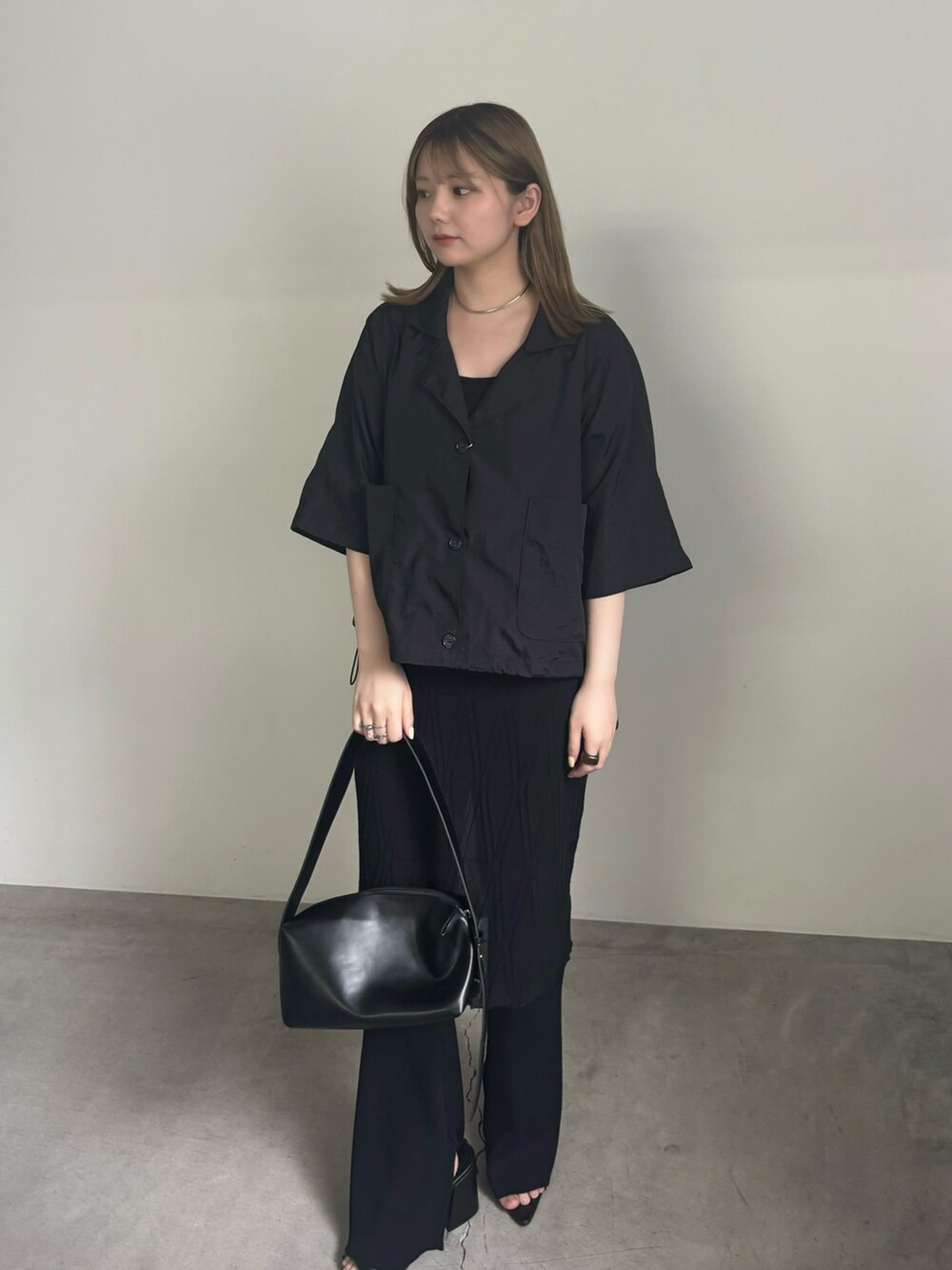 ブラック系のテーラードジャケット、ブラック系のキャミソール、ブラック系のスカートを着用したレディースの夏コーディネートの2枚目の写真