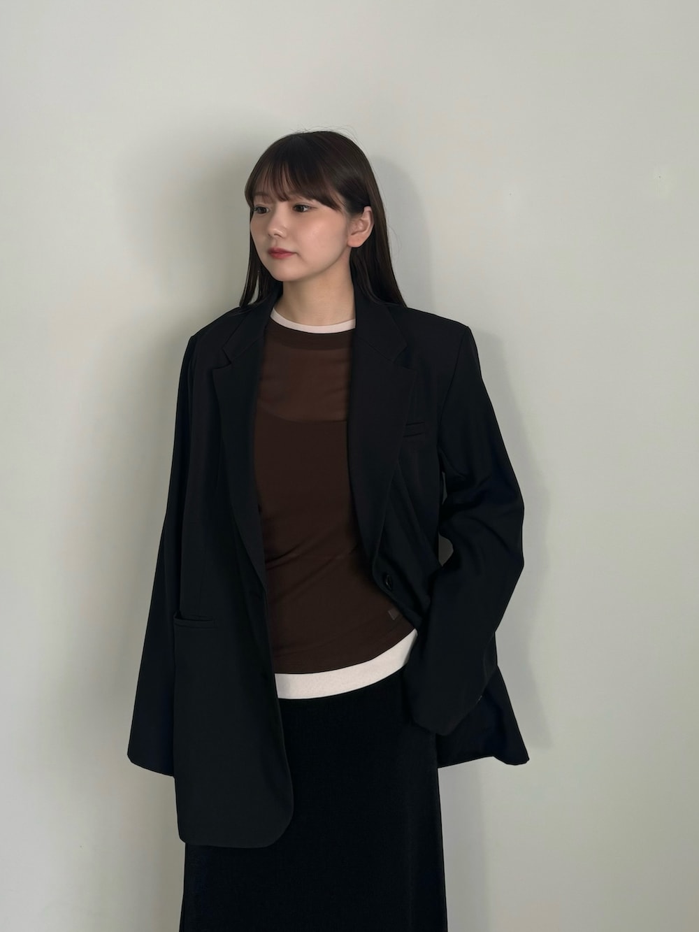 ブラウン系のTシャツ/カットソー、ブラック系のテーラードジャケット、ブラック系のスカートを着用したレディースの冬コーディネートの5枚目の写真