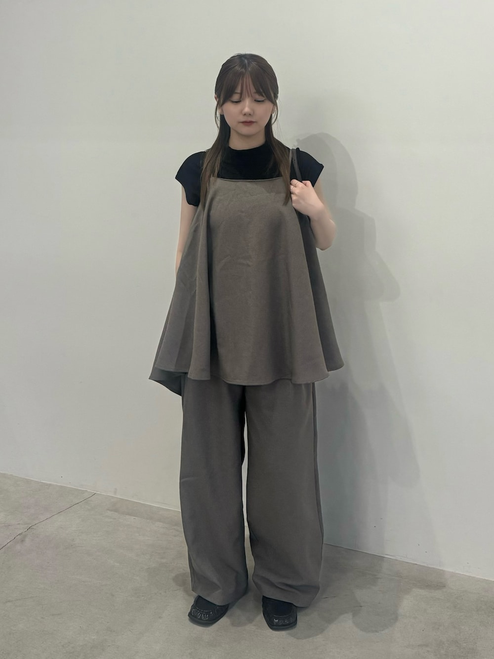 ブラウン系のキャミソール、ブラウン系のスラックス、ブラック系のTシャツ/カットソーを着用したレディースの夏コーディネートの2枚目の写真