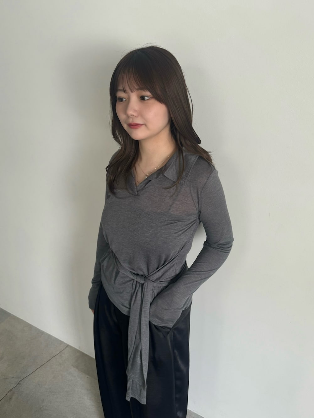 グレー系のTシャツ/カットソー、ブラック系のスラックス、ブラック系のスリッポンを着用したレディースの春コーディネートの7枚目の写真