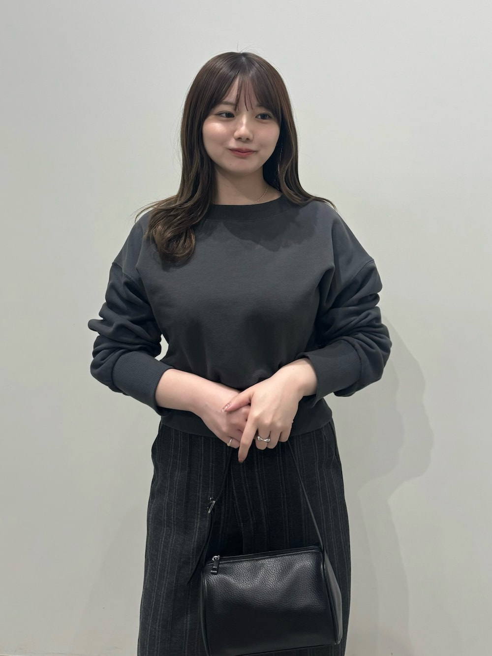 ブラック系のスウェット、ブラック系のスラックスを着用したレディースの冬コーディネートの4枚目の写真