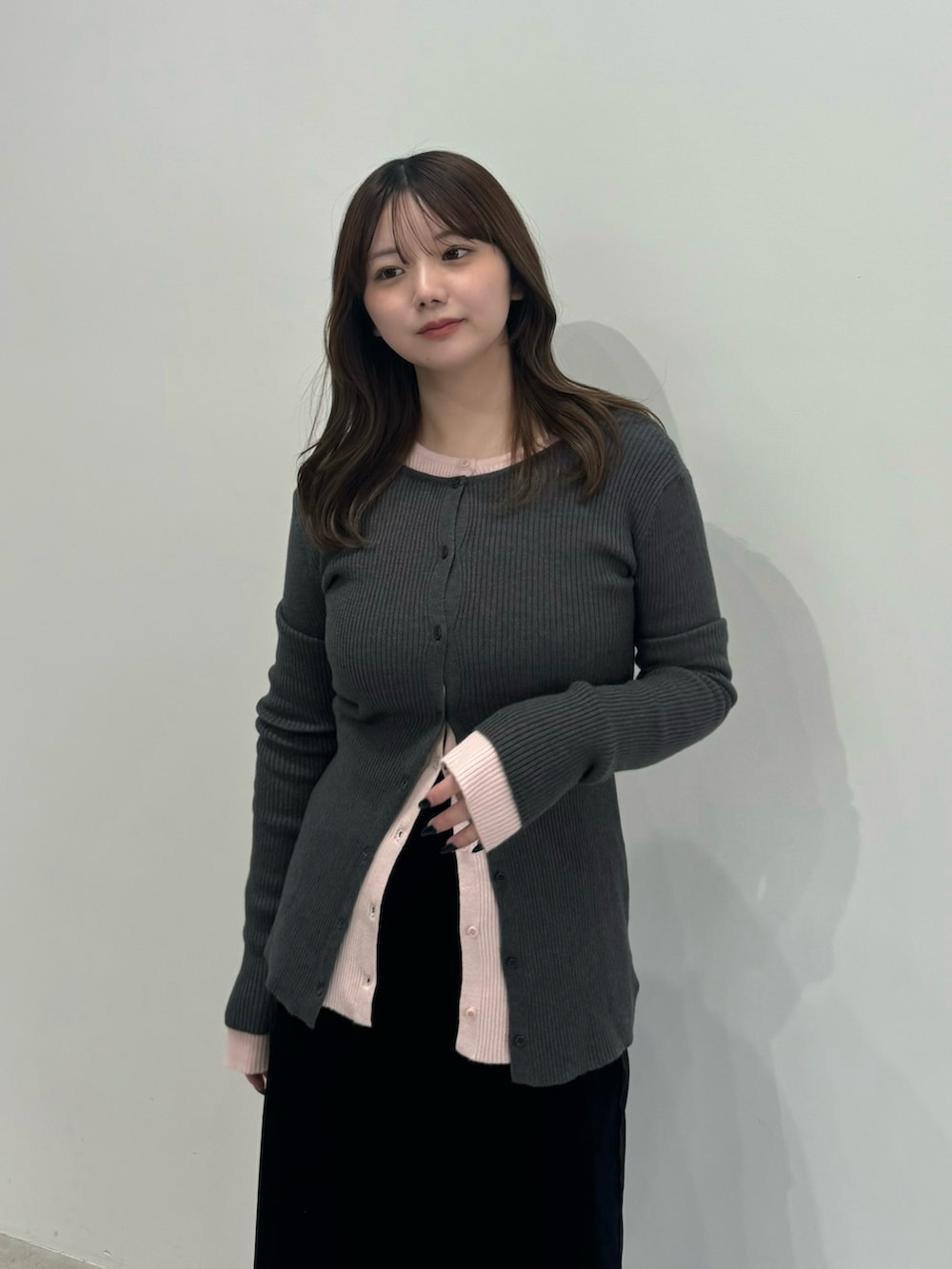 グレー系のカーディガン/ボレロ、ピンク系のカーディガン/ボレロ、ブラック系のスカートを着用したレディースの冬コーディネートの4枚目の写真