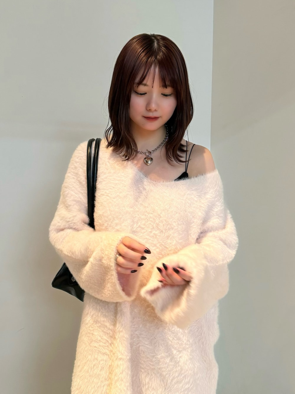 ピンク系のニット/セーター、ブラック系のスカート、ブラック系のスリッポンを着用したレディースの冬コーディネートの3枚目の写真