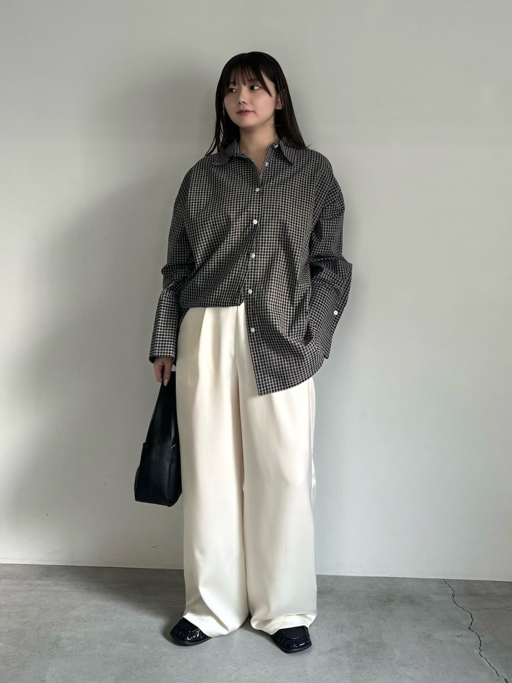 ブラック系のシャツ/ブラウス、ホワイト系のその他パンツ、ブラック系のハンドバッグを着用したレディースの春コーディネートの2枚目の写真