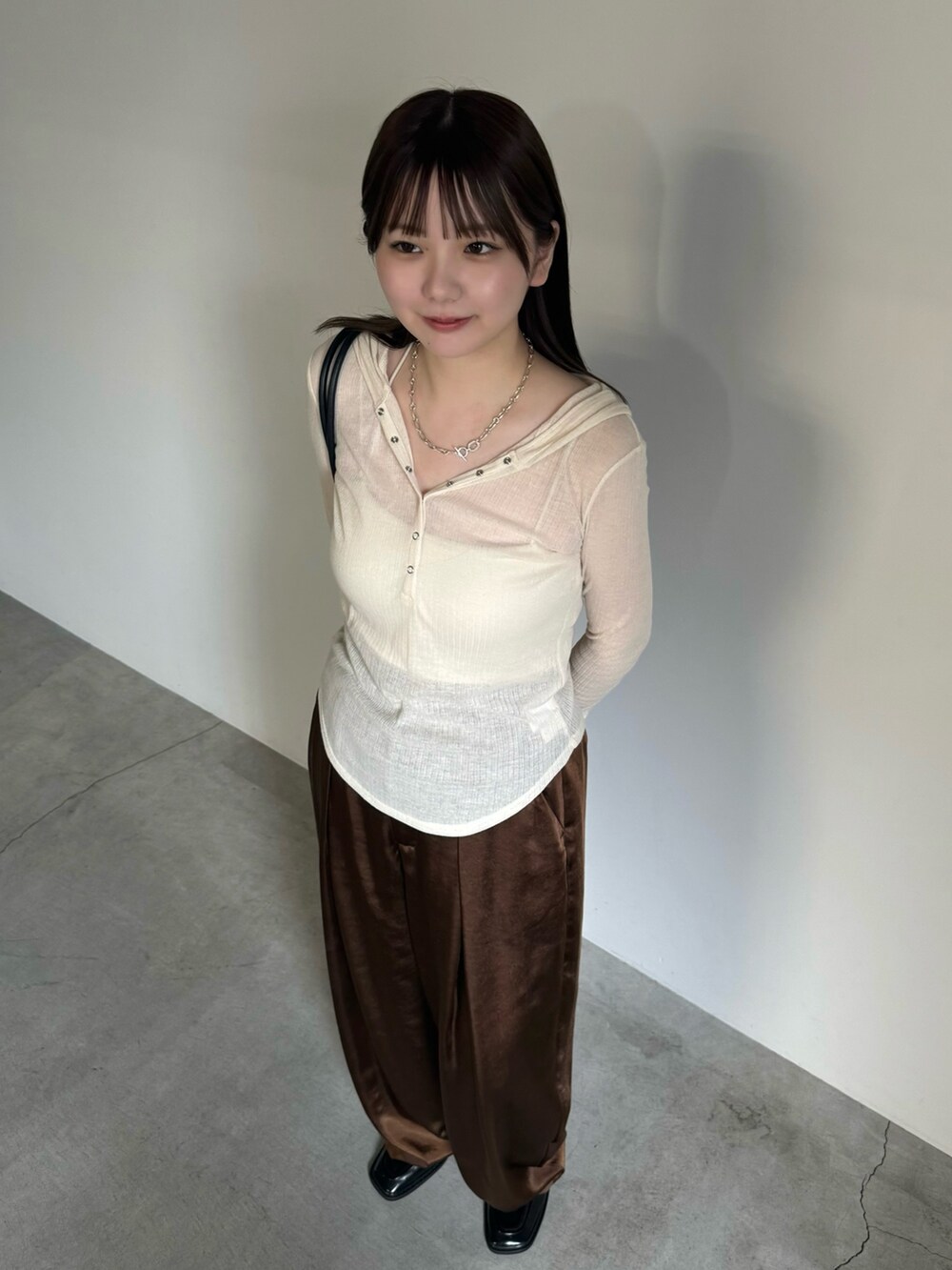 ホワイト系のTシャツ/カットソー、ホワイト系のキャミソール、ブラウン系のスラックスを着用したレディースの夏コーディネートの4枚目の写真