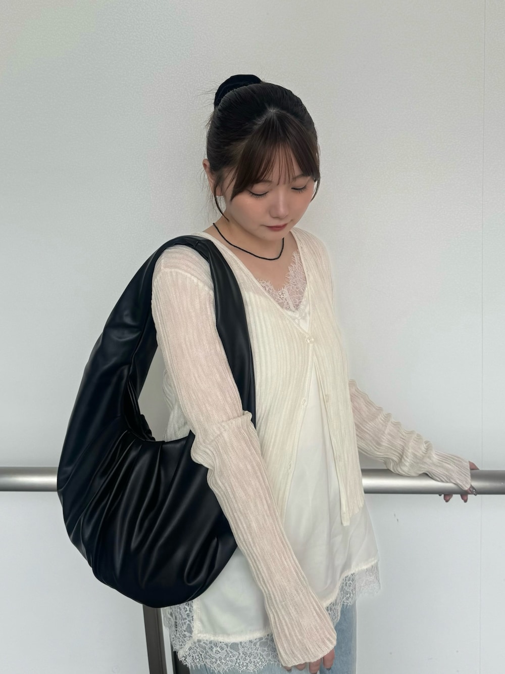 ホワイト系のキャミソール、ホワイト系のカーディガン/ボレロ、ブラック系のネックレスを着用したレディースの夏コーディネートの5枚目の写真