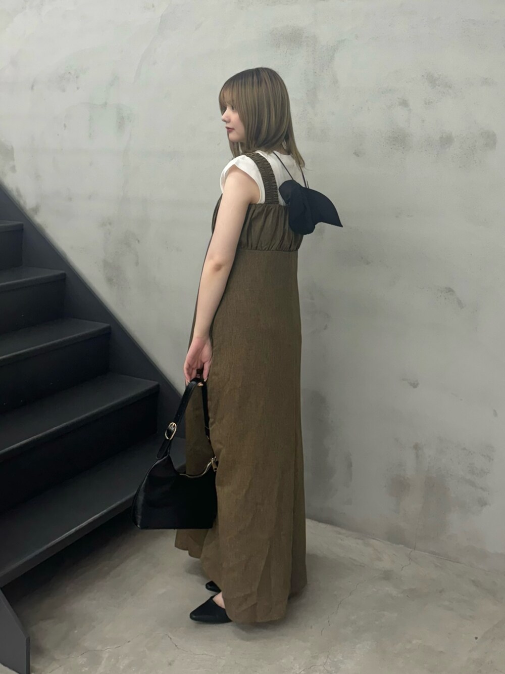 ブラウン系のワンピース、ブラック系のハンドバッグ、ホワイト系のTシャツ/カットソーを着用したレディースの夏コーディネートの3枚目の写真