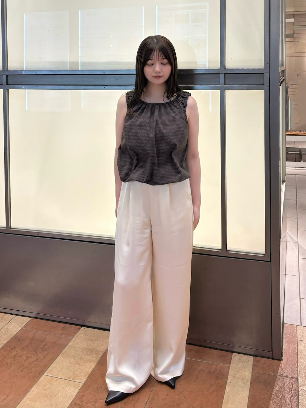 ブラウン系のタンクトップ、ホワイト系のその他パンツを着用したレディースの春コーディネートの3枚目の写真