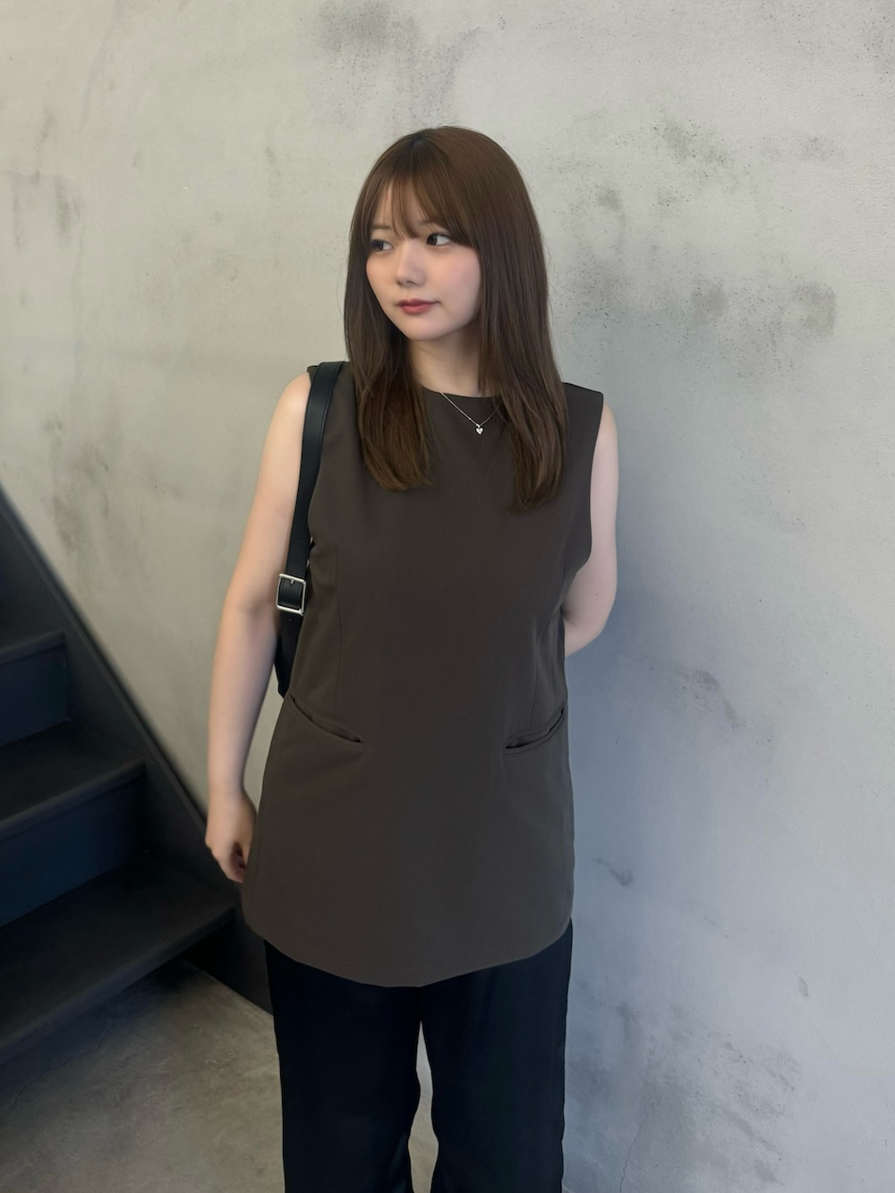 ブラウン系のベスト、ブラック系のその他パンツ、グレー系のスニーカーを着用したレディースの夏コーディネートの3枚目の写真