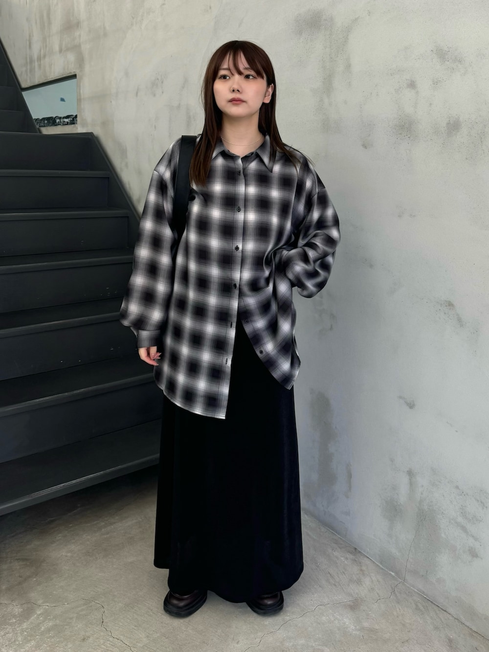 ブラック系のスカート、ブラック系のシャツ/ブラウス、ブラック系のショルダーバッグを着用したレディースの冬コーディネートの2枚目の写真