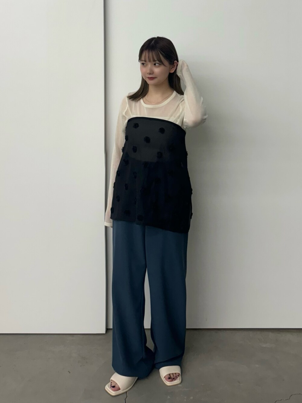 ブラック系のスカート、ホワイト系のニット/セーター、ホワイト系のキャミソールを着用したレディースの夏コーディネートの2枚目の写真