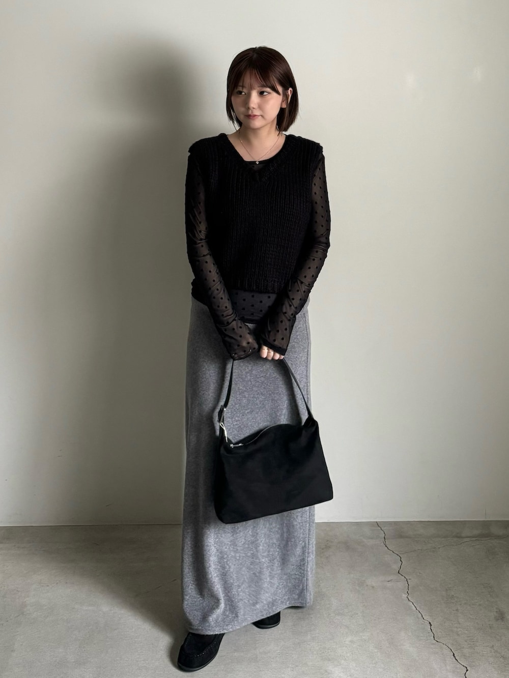 ブラック系のベスト、グレー系のスカート、ブラック系のTシャツ/カットソーを着用したレディースの秋コーディネートの3枚目の写真